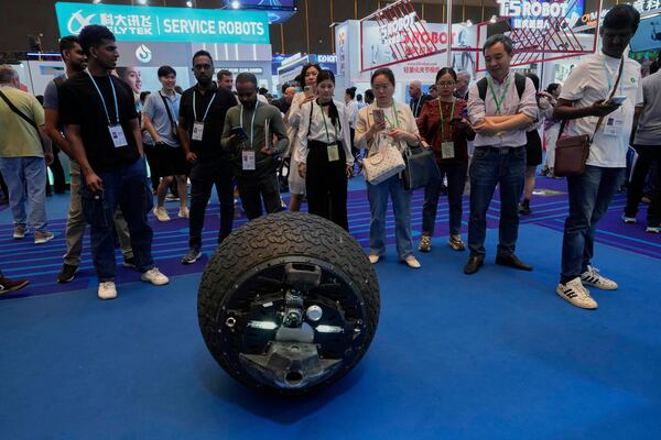 Visitors look at a wheel shaped patrol robot at the 137th Canton Fair in Guangzhou in southern China's Guangdong province on Wednesday, April 16, 2025. (AP Photo/Ng Han Guan)