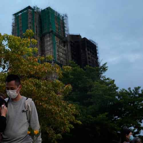 A man consoles a woman at the site of last weeks deadly fire at Wang Fuk Court, a residential estate in the Tai Po district of Hong Kong's New Territories on Tuesday, Dec. 2, 2025. (AP Photo/Ng Han Guan)