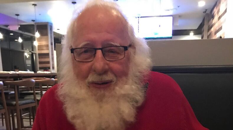 Santa Phil eats a chicken wing. LIGAYA FIGUERAS/LFIGUERAS@AJC.COM