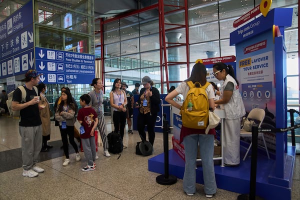 Tourists wait to take a half-day tour to the tourism destination which was offered by a travel agency Trip.com Group, at the Beijing Capital International Airport, in Beijing on June 15, 2025. (AP Photo/Andy Wong)
