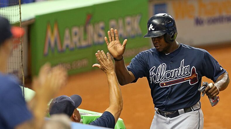 MIAMI, FL - JULY 09: Justin Upton #8 of the Atlanta Braves is congratulated after scoring during a game against the Miami Marlins at Marlins Park on July 9, 2013 in Miami, Florida. (Photo by Mike Ehrmann/Getty Images)