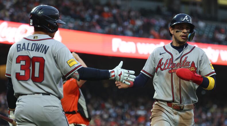 Atlanta Braves' Mauricio Dubón, right, is congratulated by Drake Baldwin (30) after scoring on a single by Ozzie Albies during the third inning of a baseball game against the San Francisco Giants in San Francisco, Friday, June 26, 2026. (AP Photo/Jed Jacobsohn)