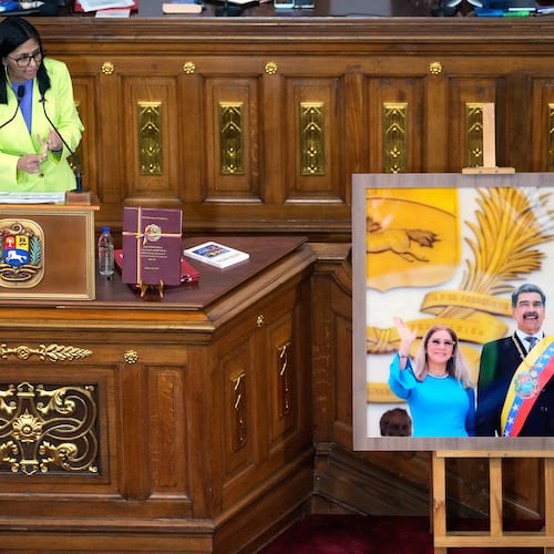 FILE - Venezuela's acting President Delcy Rodriguez addresses lawmakers next to a picture of former President Nicolas Maduro and his wife Cilia Flores, at the National Assembly in Caracas, Venezuela, Thursday, Jan. 15, 2026. (AP Photo/Ariana Cubillos, File)