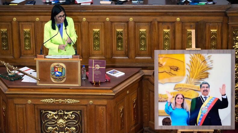 FILE - Venezuela's acting President Delcy Rodriguez addresses lawmakers next to a picture of former President Nicolas Maduro and his wife Cilia Flores, at the National Assembly in Caracas, Venezuela, Thursday, Jan. 15, 2026. (AP Photo/Ariana Cubillos, File)