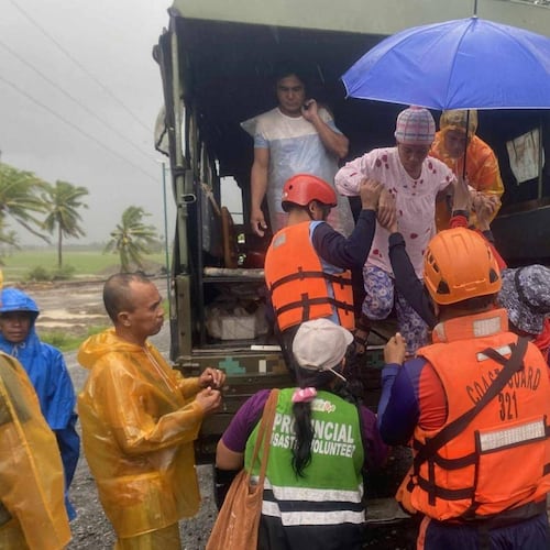 In this photo provided by the Philippine Coast Guard, rescuers evacuate residents in Sablayan, Occidental Mindoro province of the Philippines as Typhoon Fung-wong batters the country on Sunday, Nov. 9 2025. (Philippine Coast Guard via AP)
