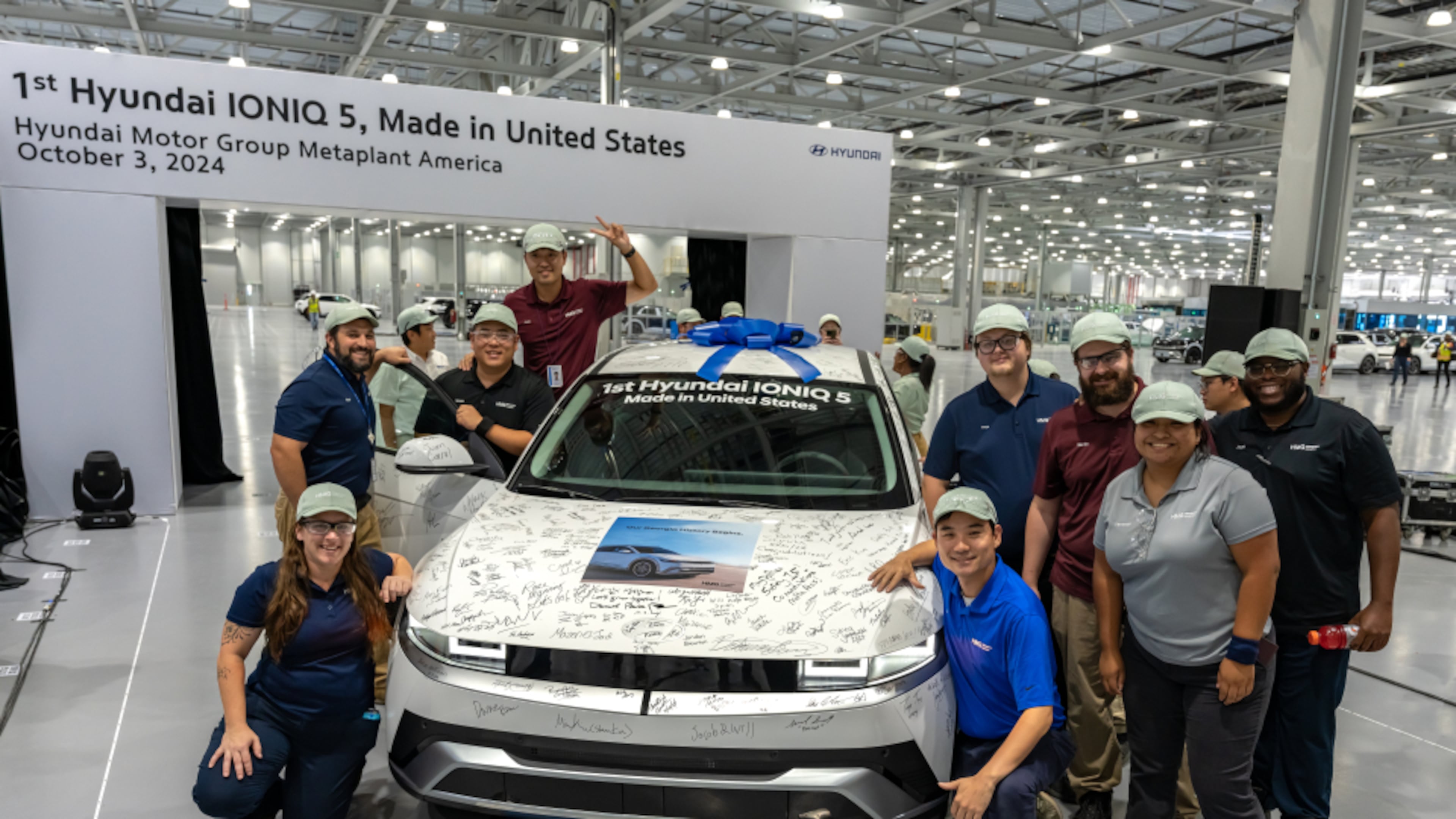 Hyundai Motor Group Metaplant America, LLC ("HMGMA") Meta Pros gather around an IONIQ 5 during the start of production celebration on Oct. 3, 2024. Each Meta Pro who attended signed the SUV to celebrate the first saleable vehicle off the line.