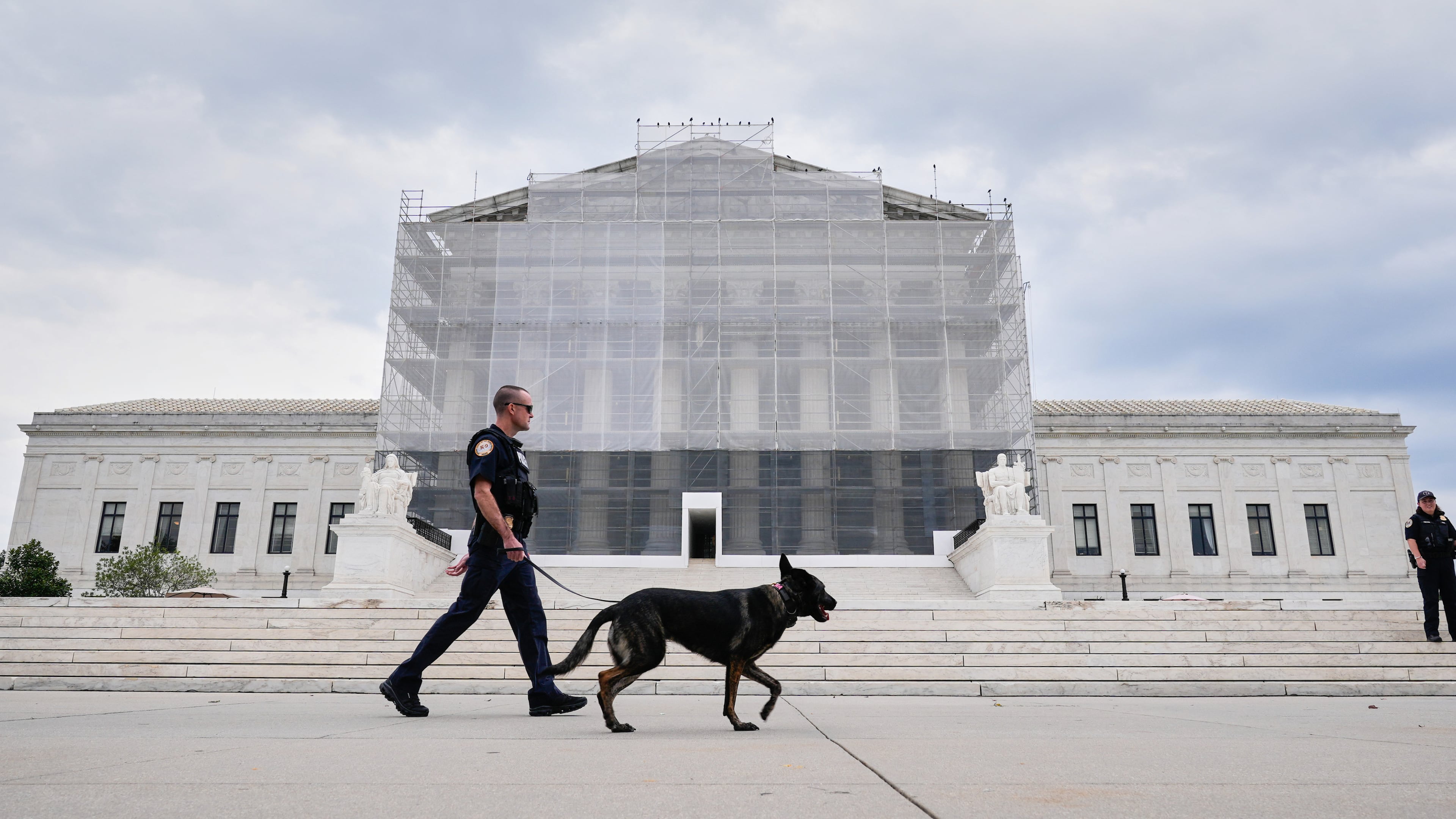 U.S. Capitol Police officers with a K9 detector dog, patrols outside of Supreme Court, Wednesday, Sept. 24, 2025, in Washington. (AP Photo/Mariam Zuhaib)