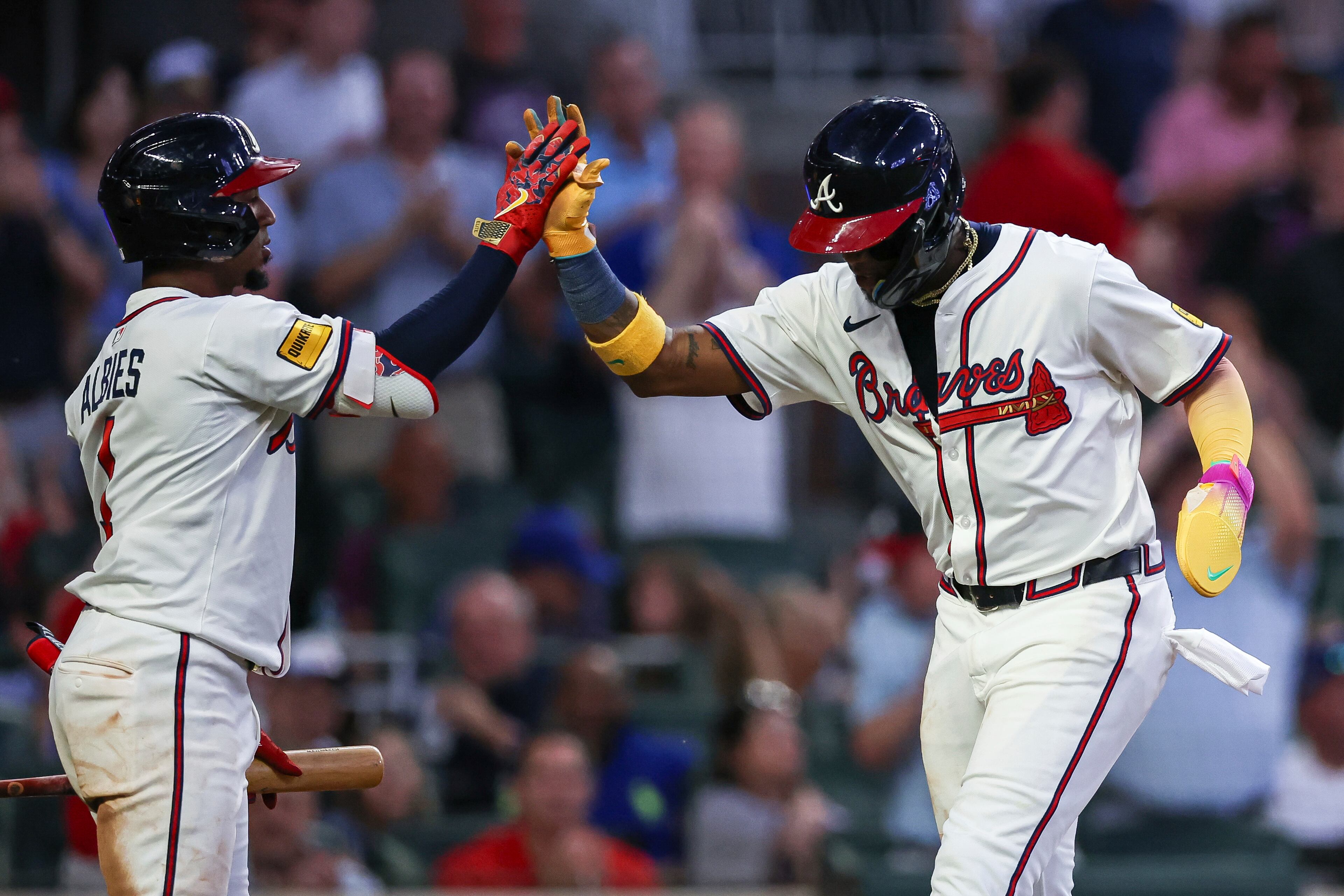 Atlanta Braves' Ozzie Albies, left, high-fives Ronald Acuña Jr., right, during the fifth inning of a baseball game against the New York Mets, Thursday, June 19, 2025, in Atlanta. (AP Photo/Colin Hubbard)