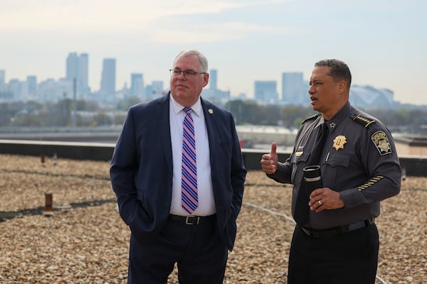 Fulton County Sheriff Patrick Labat (right) and Ken Ashley, chair of the Fulton County Sheriff’s Foundation, get a drone demonstration on the Fulton jail roof Thursday. (Jason Getz/AJC)