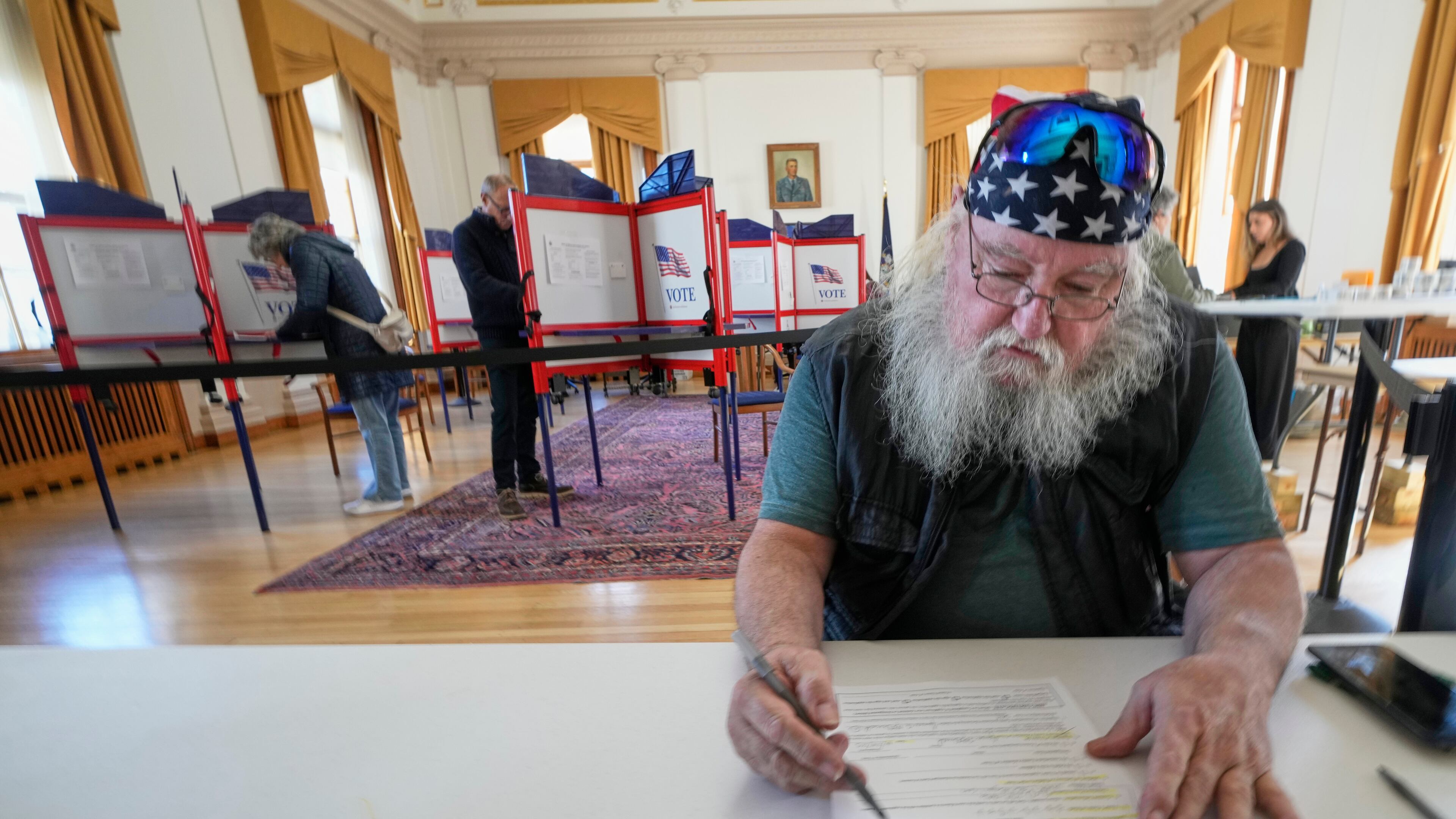 Jim McDonald fills out a form for early voting, Tuesday, Oct. 28, 2025, in Portland, Maine. (AP Photo/Robert F. Bukaty)