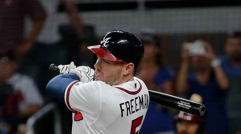 Freddie Freeman (5) follows through on a two-run base hit in the eighth inning of a baseball game against the Arizona Diamondbacks, Friday, July 14, 2017, in Atlanta. (AP Photo/John Bazemore)