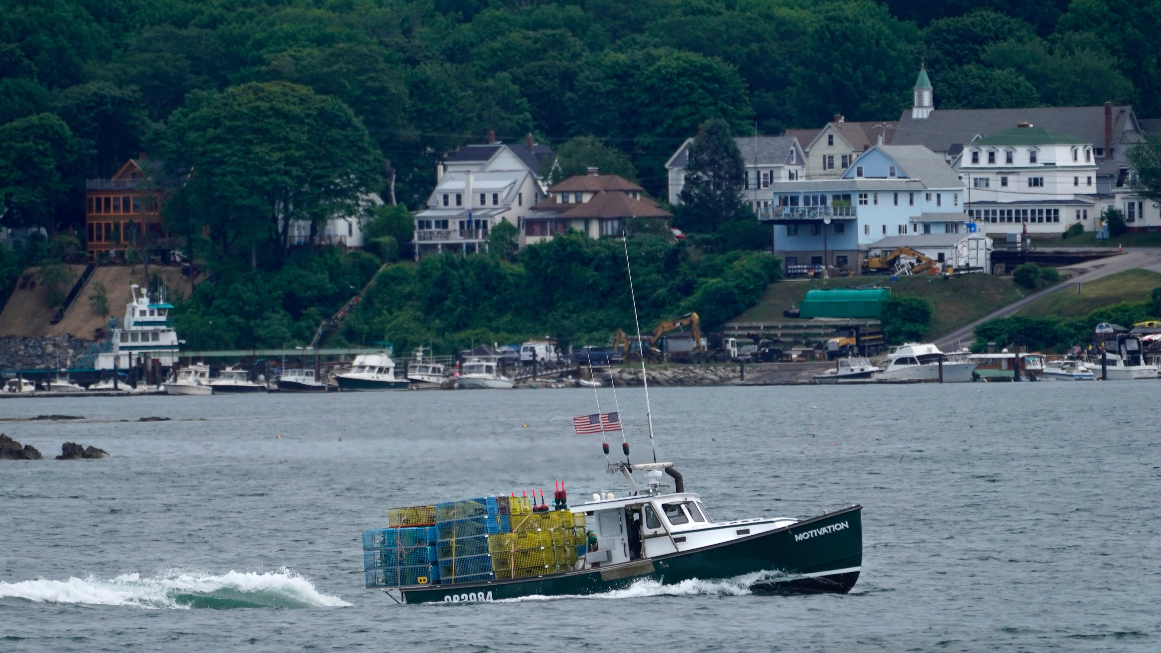 FILE - In this July 8, 2021, file photo, a lobster boat carries a heavy load of traps as it motors out to sea near Peaks Island in Portland, Maine. (AP Photo/Robert F. Bukaty, File)