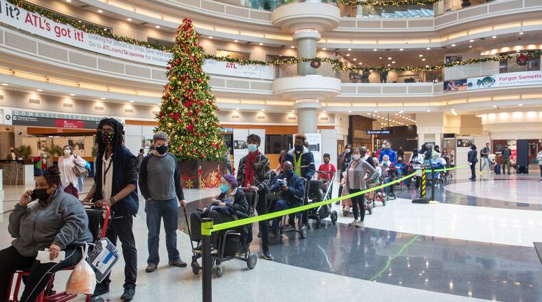 People wait in line to go through the security checkpoint at Hartsfield-Jackson International Airport on Monday, December 27, 2021. STEVE SCHAEFER FOR THE ATLANTA JOURNAL-CONSTITUTION