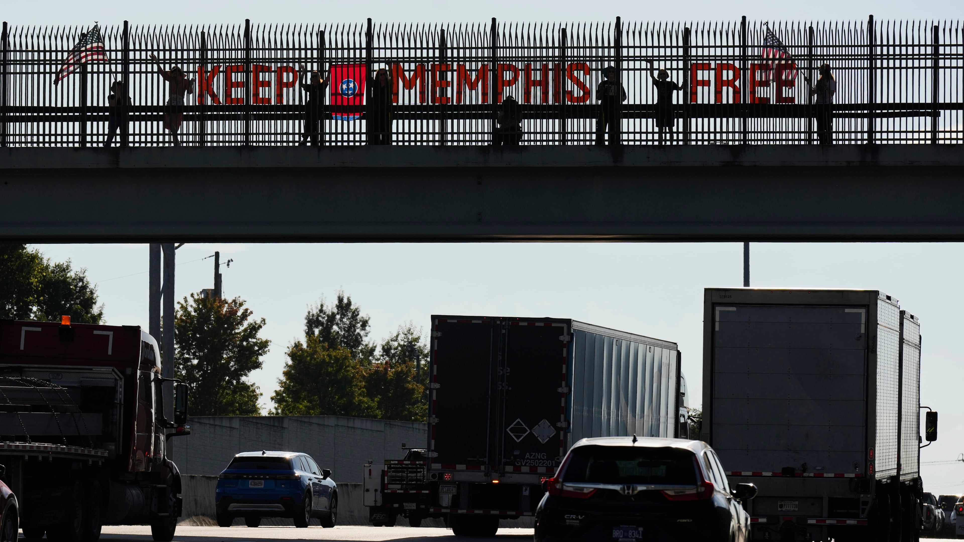 People demonstrate above Interstate 40 in Nashville, Tenn., Friday, Sept. 26, 2025, against the deployment of the National Guard in Memphis. (AP Photo/George Walker IV)