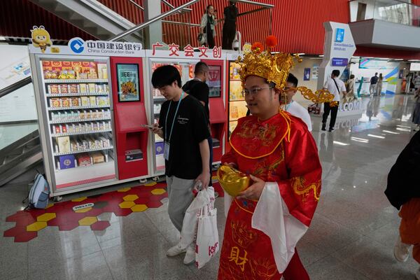 A man dressed as the god of fortune walks through the 137th Canton Fair in Guangzhou in southern China's Guangdong province on Wednesday, April 16, 2025. (AP Photo/Ng Han Guan)