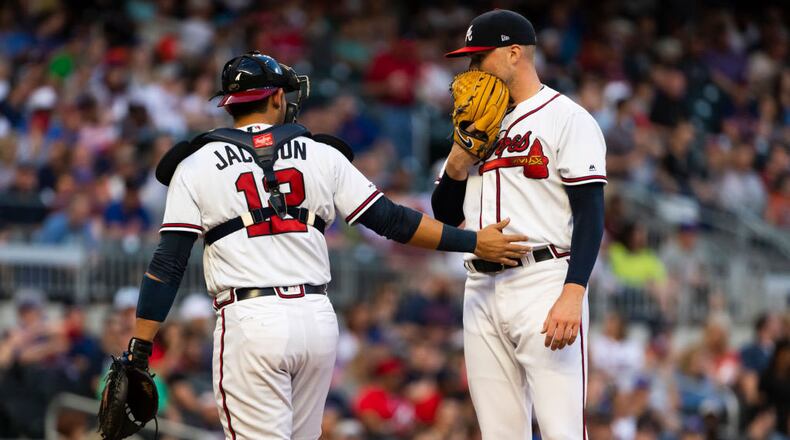 Braves catcher Alex Jackson  heads back to the plate after talking with pitcher Sean Newcomb during the second inning Saturday, April 13, 2019, at SunTrust Park in Atlanta.