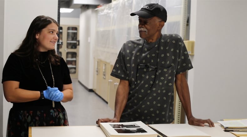 Emory University intern Anna Clark and Tom Dorsey with Dorsey's collection of black-and-white photographs of the West Side of Chicago. 'A Very Incomplete Self-Portrait: Tom Dorsey's Chicago Portfolio' is at the Michael C. Carlos Museum through July 16. Photo courtesy of the Carlos Museum.