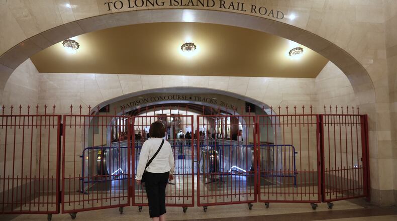 A passenger looks at a closed off entrance to the Long Island Rail Road at Grand Central station, Saturday, May 16, 2026, in New York, on the first day of a strike after five unions representing about half the LIRR's workforce walked off the job. (AP Photo/Heather Khalifa)
