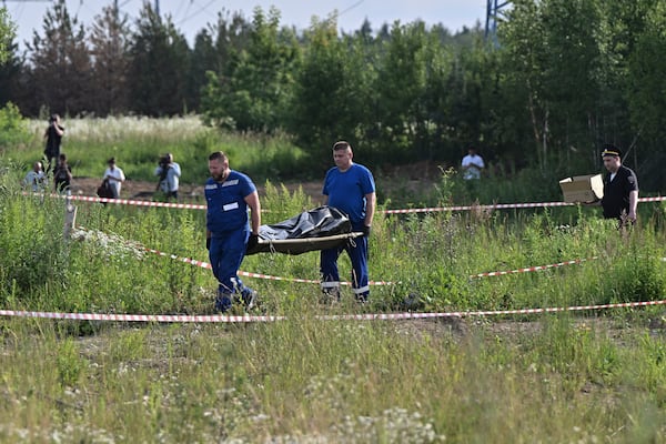Russian law enforcement agents carry the body of former Transportation Minister Roman Starovoit, who was found dead from a gunshot wound in an apparent suicide, investigators said Monday, hours after his dismissal in Odintsovo, outside Moscow, Russia, Monday, July 7, 2025. (Evgeniy Razumniy/Kommersant Photo via AP)