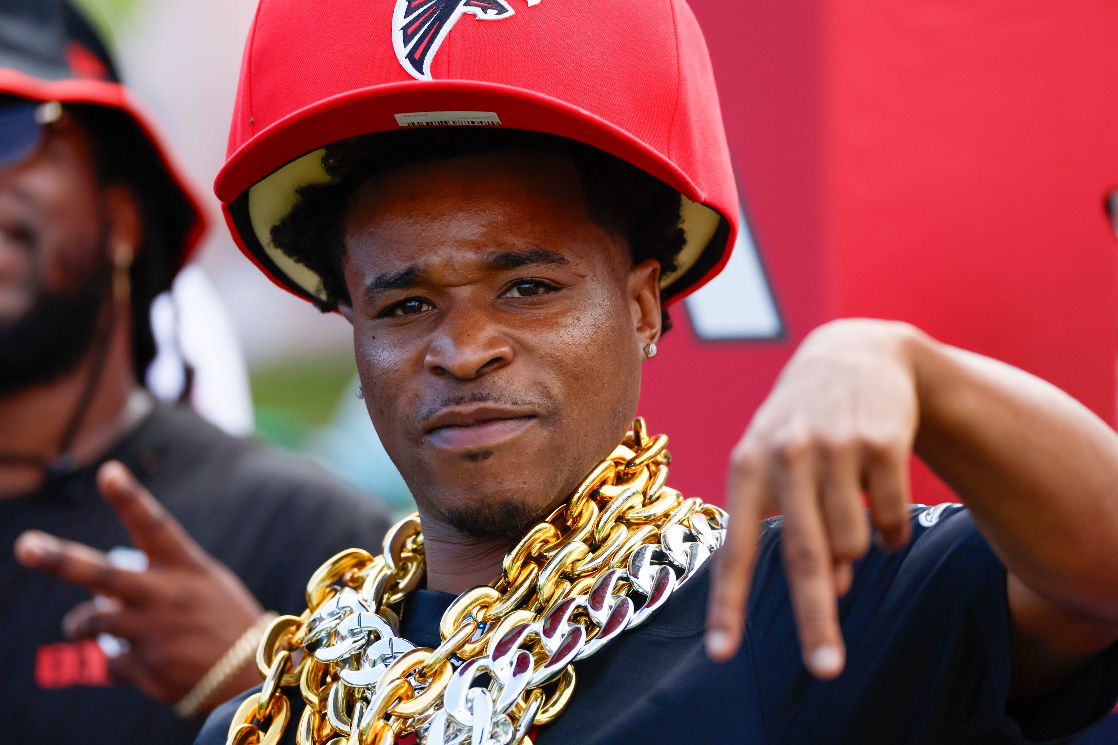 An Atlanta Falcons fan signals to the camera as he watches the first practice of training camp on Thursday, July 24, 2025, in Flowery Branch. (Miguel Martinez/AJC)