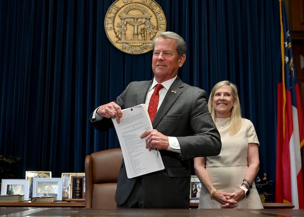 Gov. Brian Kemp and first lady Marty Kemp smile after the governor signed the state’s new budget on Tuesday. (Hyosub Shin/AJC)