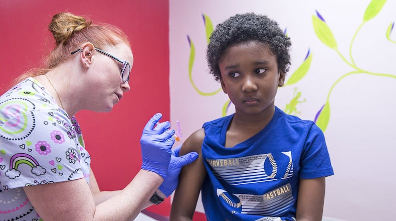 In this file photo, Logan Edwards, 7, of Conyers, receives an Influenza Vaccine shot from LPN Katie Childress during his visit to Conyers Pediatrics in Conyers. (Alyssa Pointer/Atlanta Journal Constitution)