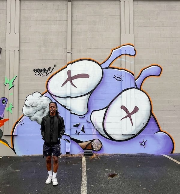 Oskiade Jaleel has a smoke after completing his mural. (Courtesy of Arthur Rudick)