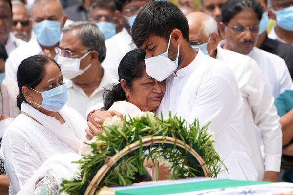 Rushabh Rupani, son of former Chief Minister of Gujarat Vijay Rupani, consoles his mother Anjali Rupani as they receive the body of Vijay Rupani, who died in Thursday's Air India plane crash, in Ahmedabad, India, Monday, June 16, 2025. (AP Photo/Ajit Solanki)