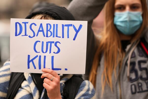 Protesters show placards as Britain's Chancellor Rachel Reeves is about to leave 11 Downing Street to deliver the spring statement in London, Wednesday, March 26, 2025. (AP Photo/Kirsty Wigglesworth)