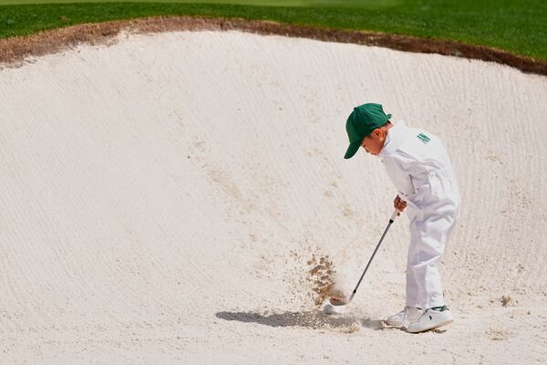 Byeong Hun An's, of South Korea, son Sun-woo, 5, hits out of the bunker on the first hole during the par-3 contest at the Masters golf tournament, Wednesday, April 9, 2025, in Augusta, Ga. (AP Photo/Ashley Landis)
