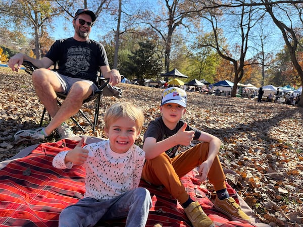 Matt Mastin and his sons Arthur and Oscar (right) give a thumbs up to the food at the Atlanta Halal Fall Festiva in Grant Park behind them. (Ariel Hart/AJC)