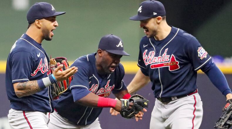 Braves outfielders Eddie Rosario (8), Jorge Soler (12) and Adam Duvall (14) celebrate the 3-0 victory in Game 2 of the NLDS series against he Milwaukee Brewers Saturday, Oct. 9, 2021, in Milwaukee. (Curtis Compton / Curtis.Compton@ajc.com)