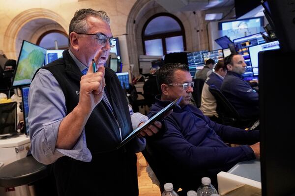 Trader John Bishop, left, works with colleagues on the floor of the New York Stock Exchange, Monday, April 21, 2025. (AP Photo/Richard Drew)