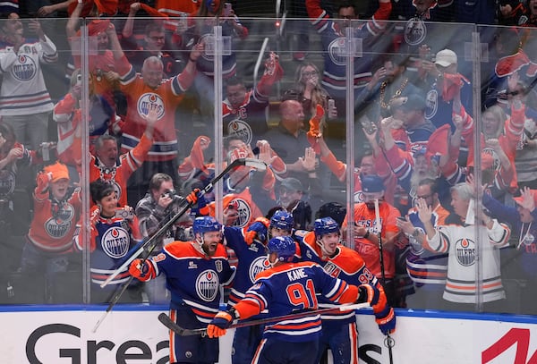 Edmonton Oilers' Leon Draisaitl, from left to right, Evan Bouchard, Evander Kane, Ryan Nugent-Hopkins celebrate Draisaitl's winning goal during the first overtime period in Game 1 of the NHL Stanley Cup Final against the Florida Panthers, in Edmonton, Alberta, on Wednesday, June 4, 2025. (Darryl Dyck//The Canadian Press via AP)