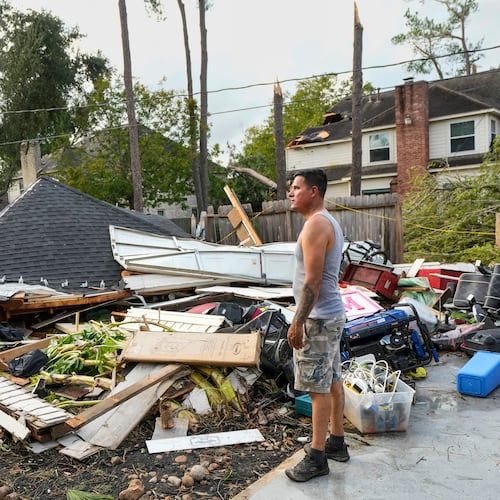 Jose Rosas surveys damage to Guillermo Vargas' home as while helping clean up storm damage in the Memorial Northwest subdivision, in Spring, Texas, Monday, Nov. 24, 2025. (Brett Coomer/Houston Chronicle via AP)