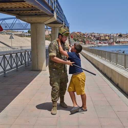 A 12-year-old unaccompanied minor who crossed into Spain is escorted by a Spanish soldier to the Spain-Morocco border as the child begs not to be sent back to Morocco from the Spanish enclave of Ceuta, Monday, Aug. 3, 2026. The forced deportation of the unaccompanied minor was stopped by a high-ranking official a few meters before the child reached the border after residents and journalists said the migrant was a minor. (AP Photo/Bernat Armangue)