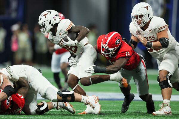 Georgia linebacker Jalon Walker (11) tackles Texas running back Quintrevion Wisner (26) during the 2024 SEC Championship game at Mercedes-Benz Stadium, Saturday, December 7, 2024, in Atlanta. Georgia won 22-19 in overtime. Jason Getz / AJC)
