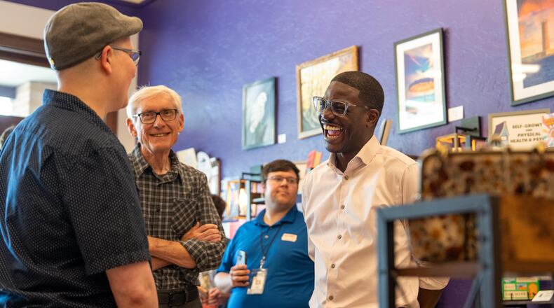 David Crowley, right, Democratic candidate for Wisconsin governor talks with CJ Arthur, left, owner of WordHaven BookHouse during a campaign stop with Wisconsin Gov. Tony Ever, center, Friday, Aug. 7, 2026, in Sheboygan, Wis. (AP Photo/Kayla Wolf)