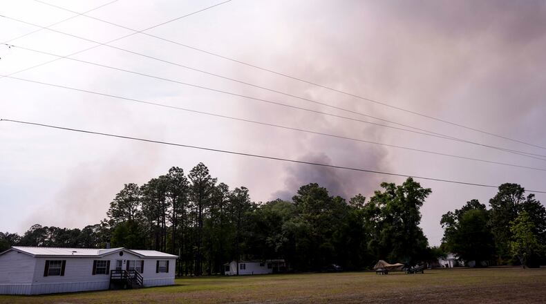 The Pineland road fire in Brantley, county burns behind homes, Wednesday, April 22, 2026, near Nahunta, Ga. (AP Photo/Mike Stewart)