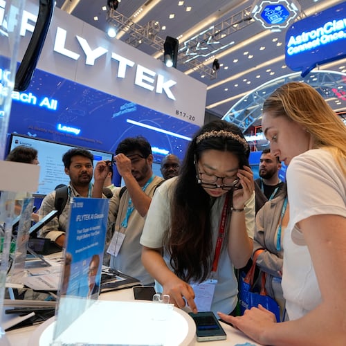 Foreign visitors try out the AI-powered glasses by iFLYTEK at the Canton Fair, in Guangzhou, in southern China's Guangdong province, Wednesday, April 15, 2026. (AP Photo/Andy Wong)