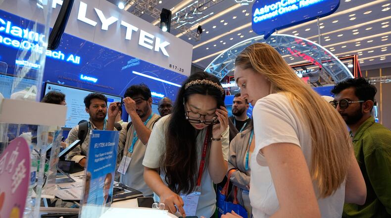 Foreign visitors try out the AI-powered glasses by iFLYTEK at the Canton Fair, in Guangzhou, in southern China's Guangdong province, Wednesday, April 15, 2026. (AP Photo/Andy Wong)