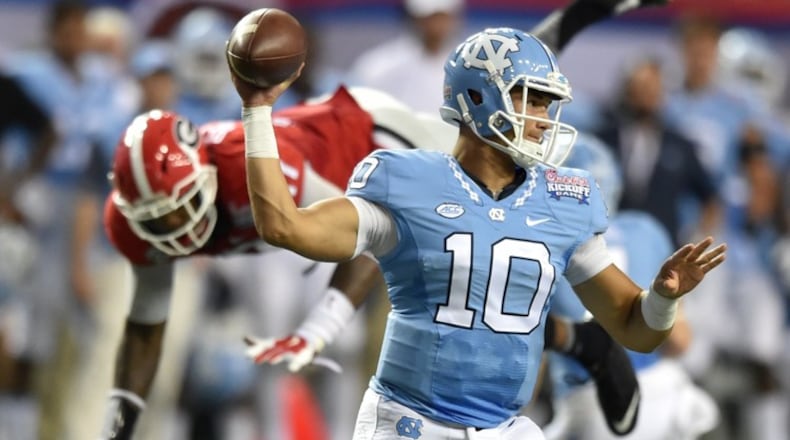 090316 Atlanta: North Carolina Tar Heels quarterback Mitch Trubisky throws as Georgia Bulldogs linebacker Davin Bellamy leaps over a defender during the second half of the Chick-fil-A Kickoff Game at the Georgia Dome Saturday September 3, 2016. BRANT SANDERLIN/BSANDERLIN@AJC.COM