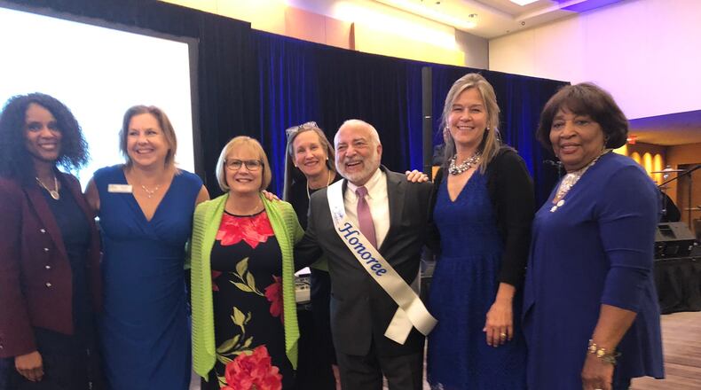 Fulton County Schools board members surround retiring Chief Financial Officer Robert Morales, center, who is retiring.