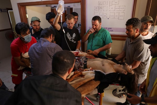 A Syrian government soldier who was injured in Sweida city during clashes between the Syrian government forces and Druze militias, receive treatments at a clinic in Busra al-Harir village, southern Syria, Tuesday, July 15, 2025. (AP Photo/Omar Albam)