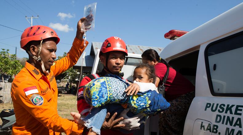 Rescuers carry a young earthquake survivor into an ambulance in North Lamba Leda, East Nusa Tenggara province, Indonesia, Tuesday, Aug. 18, 2026. (AP Photo/Firdia Lisnawati)