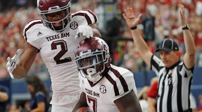 Texas A&M Aggies running back Keith Ford (7) and wide receiver Jhamon Ausbon (2) celebrate after Ford's 44-yard touchdown run in the third quarter on Saturday, Sept. 23, 2017 in the Southwest Classic in Arlington, Texas. (Paul Moseley/Fort Worth Star-Telegram/TNS)