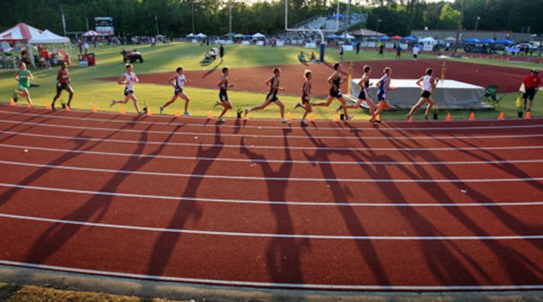110506 - Jefferson, Ga. - The late afternoon sunlight casts long shadows of the lead pack during the Class AAAA 3,200 meter run final at the Boys High School Track event at Memorial Stadium Friday afternoon in Jefferson, Ga., May 6, 2011. Jason Getz jgetz@ajc.com