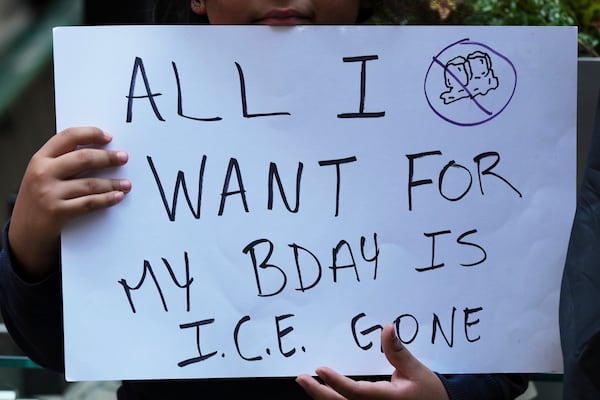 A demonstrator holds a sign outside of Immigration Court, Monday, June 16, 2025, in Chicago. (AP Photo/Nam Y. Huh)