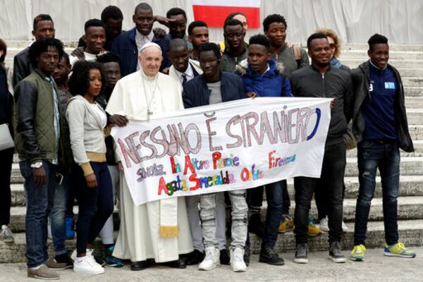 FILE - Pope Francis meets a group of migrants taking part in a project on social integration organized by the charity "Agata Smeralda", during his weekly general audience, in St.Peter's Square at the Vatican, Wednesday, April 11, 2018. Writing on the banner reads in Italian "No one is foreign". (AP Photo/Andrew Medichini, file)