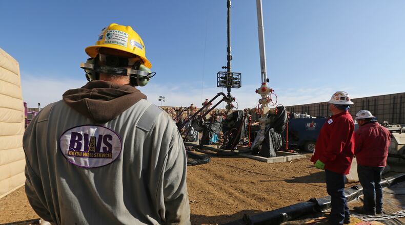 In this March 25, 2014 photo, workers keep an eye on well heads during a hydraulic fracturing operation at an Encana Corp. oil well, near Mead, Colo. The first experimental use of hydraulic fracturing was in 1947, and more than 1 million U.S. oil and oil wells have been fracked since, according to the American Petroleum Institute. The National Petroleum Council estimates that up to 80 percent of natural oil wells drilled in the next decade will require hydraulic fracturing. (AP Photo/Brennan Linsley)